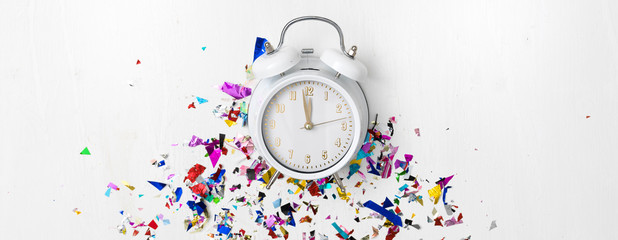 alarm clock on white background with different colorful new year items