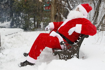 Père noël relaxe sur un banc de parc