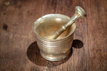 Copper mortar and pestle gold on a wooden table