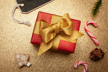 Geschenk zu Weihnachten 
mit einer goldenen Schleife auf Gold Untergrund