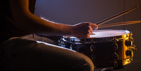 man playing the snare drum on a beautiful colored background