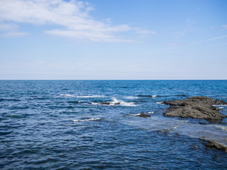 Beautiful blue sea with black sand beach and sky of Jeju island in Korean