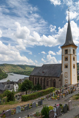 Fototapeta na wymiar The cemetery with the Church of the village of Zell in the valley of the Moselle.