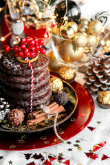 Christmas, xmas ginger bread with rowan, mountain ash and sweets, cookies on red plate, golden balls and confetti with cinnamon, chrismas cone