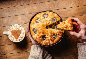 Homemade pie near cup of coffee on wooden table. Above view