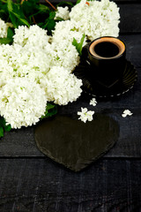 Obraz na płótnie Canvas Cup of coffee with bouquet flower hydrangea and slate heart