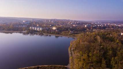 Fototapeta premium Widok z lotu ptaka na jesienny park miejski w pobliżu jeziora.