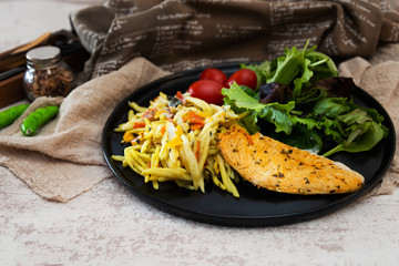 close-up of plate of pasta and chicken with lettuce