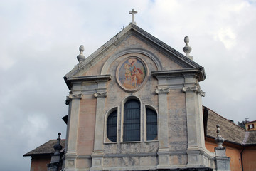 Facciata di chiesa barocca con finestra trifora e affresco circolar