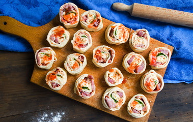 Raw pIzza rolls pastry on a wooden board