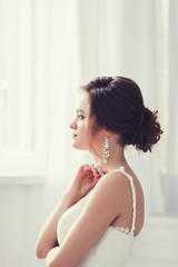 Fototapeta na wymiar Beauty portrait of bride wearing fashion wedding dress with luxury hairstyle, studio indoor photo.