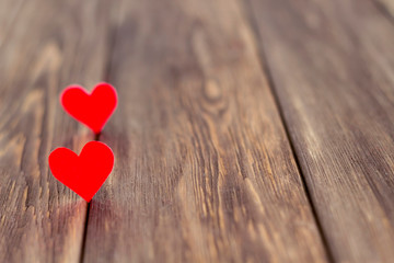 Two red hearts on old wooden background. Love concept for St. Valentine's day. Close-up, copy space