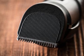 Hair trimmer and scissors on the wooden background. Beard and hair clippers.