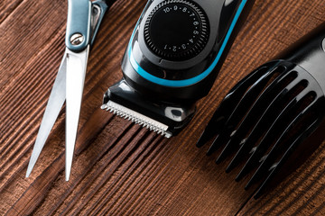 Hair trimmer and scissors on the wooden background. Beard and hair clippers.