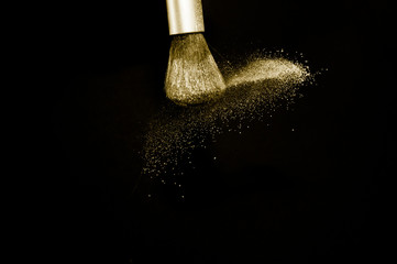 gold powder splash and silver brush for makeup artist or beauty blogger in black background, look like a luxury mood.