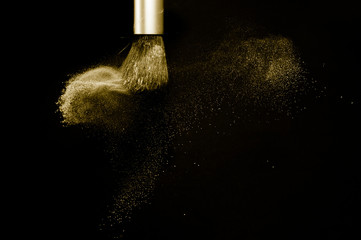 gold powder splash and silver brush for makeup artist or beauty blogger in black background, look like a luxury mood.