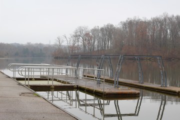 Obraz premium A view of the empty dock at the lake on a foggy fall day.