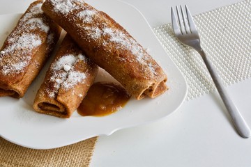 Tasty rolls with the apple jam in the white plate on the white table