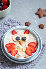Kids breakfast oatmeal porridge with berries and nuts