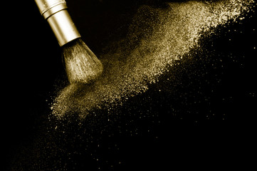 gold powder splash and silver brush for makeup artist or beauty blogger in black background, look like a luxury mood.