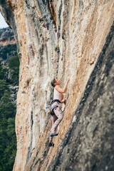 woman climbs a rock in Greece and beautiful forest and cliff landscape on the background