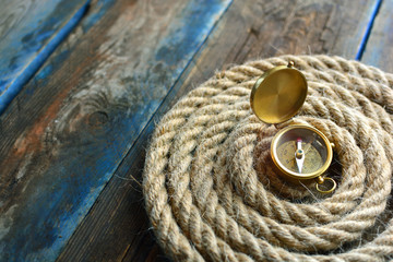 Nautical background. Sailing rope with a compass closeup.