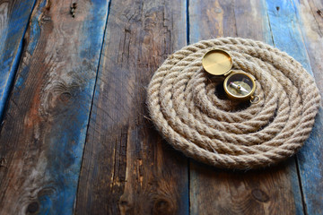 Pirate and nautical background with an old weathered deck, rope and compass. With a place for copy...