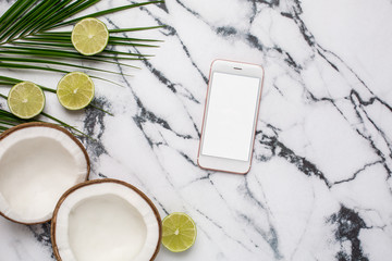 Mobile phone and tropical fruits on marble background