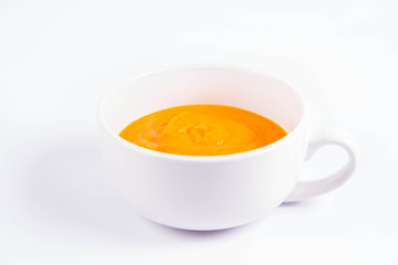 Pumpkin soup in a bowl on a white background