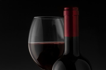 Red wine bottle and glass on the black background