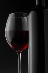 Red wine bottle and glass on the black background