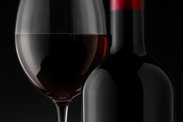 Red wine bottle and glass on the black background