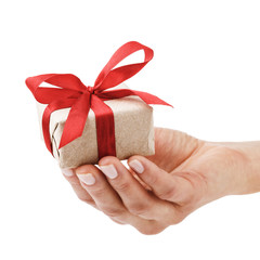 Gift tied with a red ribbon in hand closeup isolated on white background