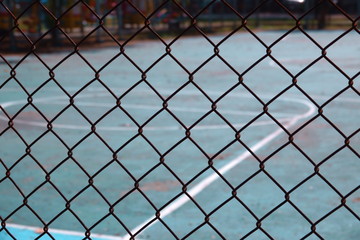 Fototapeta premium steel wire net fence with blurred green background