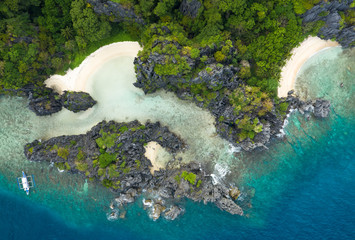 Aerial drone view of turquoise coastal waters and limestone cliffs in El Nido archipelago tourist destination of Hidden beach. El Nido, Palawan, Philippines.