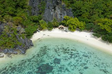 Aerial drone view of turquoise coastal waters, coral reef and limestone cliffs in El Nido...