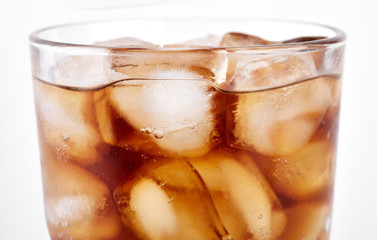 Cola in glass with straw and ice cubes isolated on white background. Soda with bubbles isolated on white. Refreshing non-alcoholic drink
