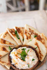Bread with cream cheese on white wooden table in the greek restaurant.
