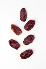 Dates on the white background in branch shape. Top view, copy space, flat lay, card layout