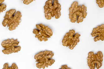Pattern of walnuts on the white background. Diet and culinary concept. Top view, flat lay