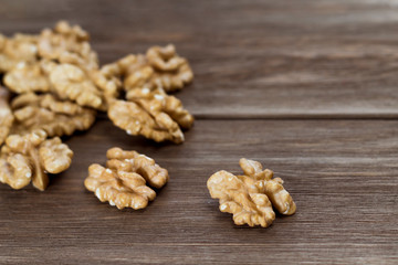 Walnuts on the wooden background. Diet and culinary concept. Close-up, soft focus, copy space