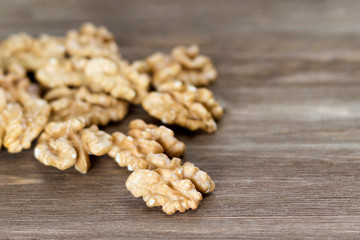 Walnuts on the wooden background. Diet and culinary concept. Close-up, soft focus, copy space