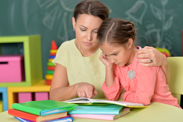 Fototapeta na wymiar Portrait of little girl with her mother doing homework