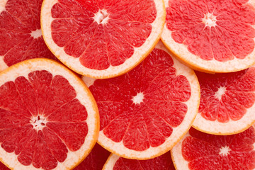 Close-up Grapefruit slices abstract background in Living Coral color of the Year 2019. Bright summer texture.