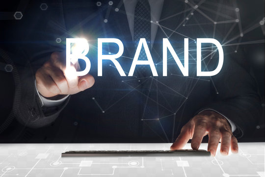 Business man touching screen with "Brand" writing