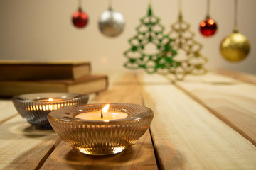 New year and Christmas compositions background with aroma candle,books and decoration Christmas ball on the table wooden