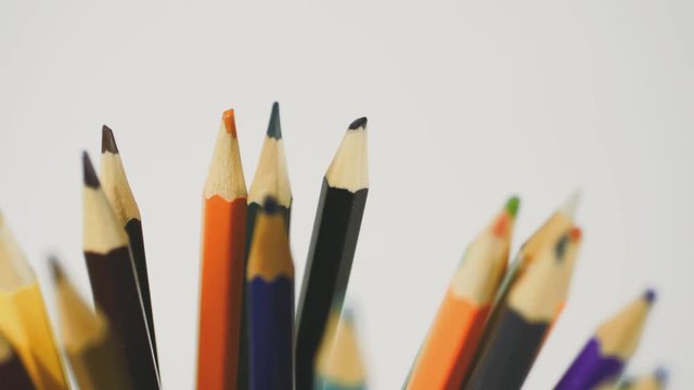 Pencil on a white background. Camera in motion. Pencils are in the glass