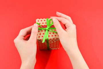 Present in woman hand on red background.
