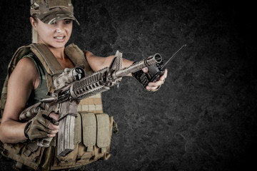 Sexy girl wearing military style posing with guns and sunglases isolated in studio