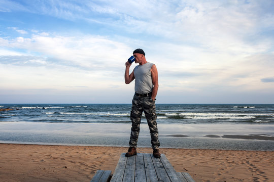 Mann trinkt Kaffee am Strand der Ostsee